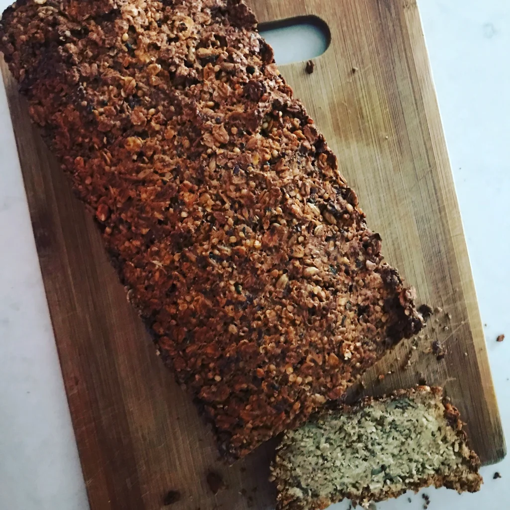 A loaf of loaded porridge bread with one slice cut off