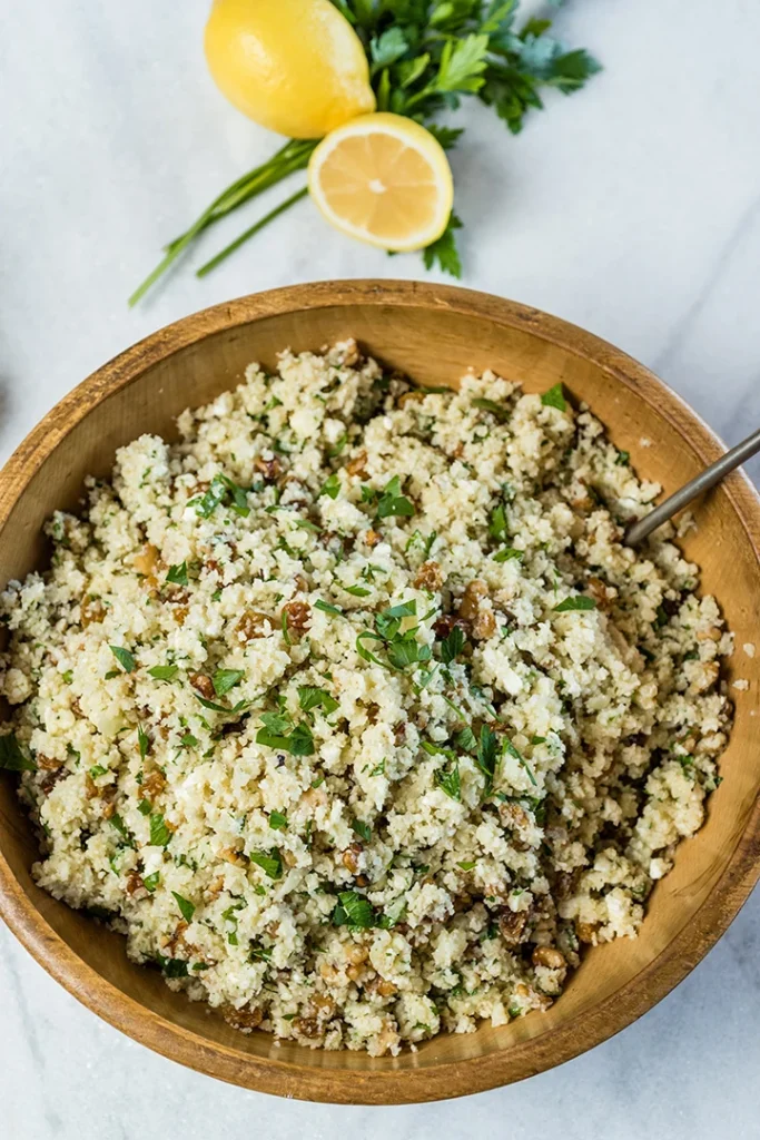 A wooden bowl filled with Mediterranean style cauliflower rice